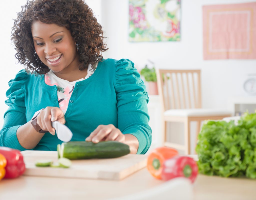 African American woman slicing vegetables